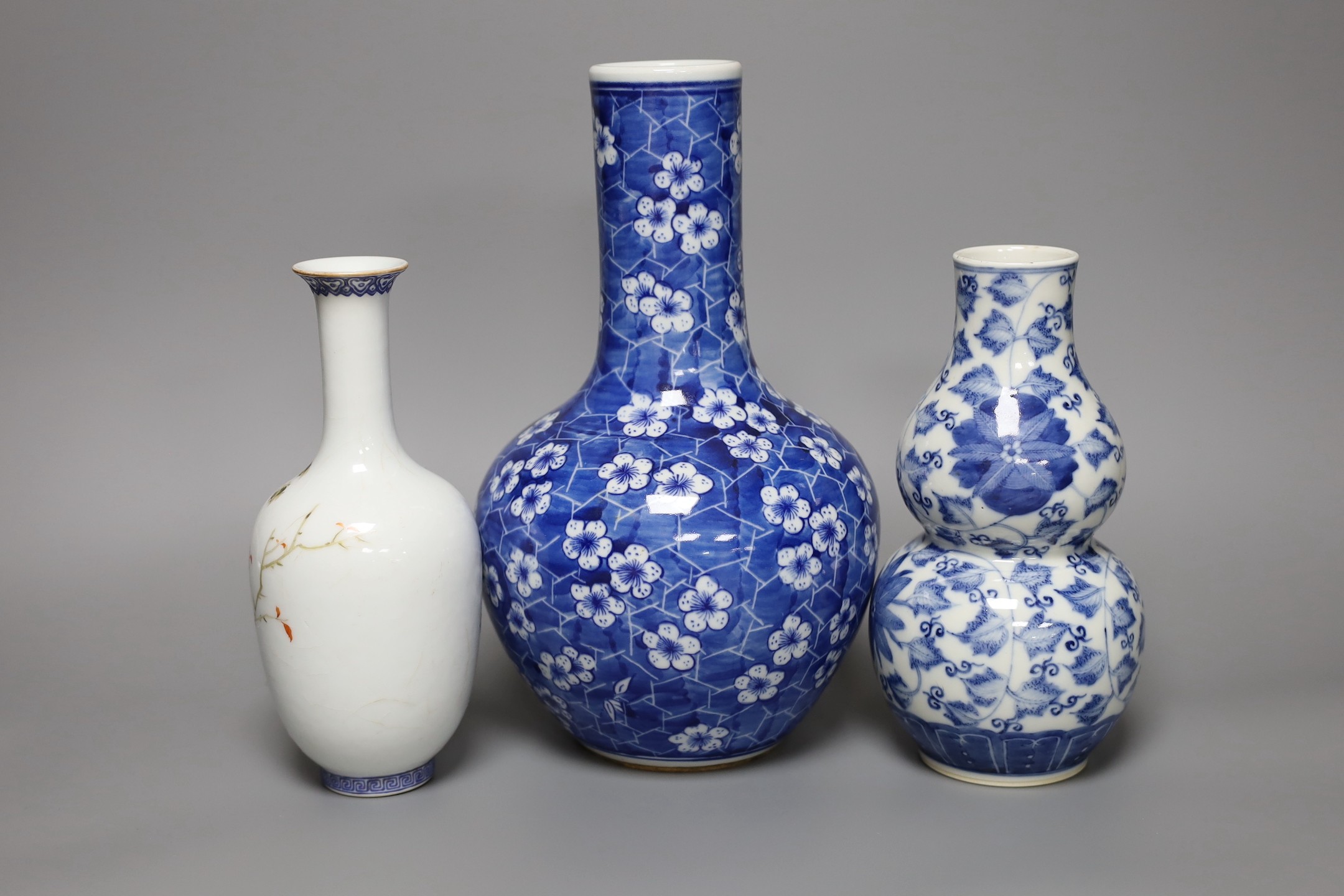 A Chinese blue and white bottle vase, a similar double gourd vase and a famille rose bottle vase a.f., tallest 26cm